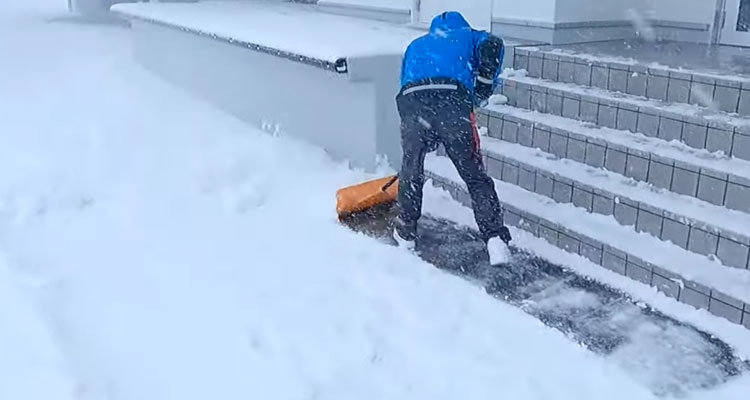 雪かきを始める野坂