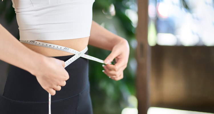 ウエストを測る女性